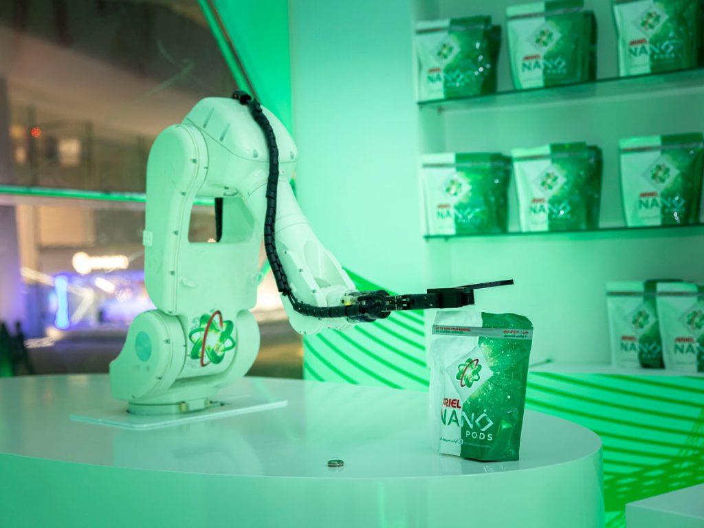 A robotic arm presenting products in an illuminated display.