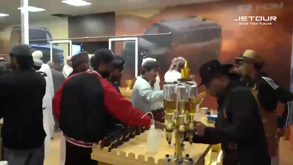 Guests and staff at a refreshment service counter during a Jetour event.