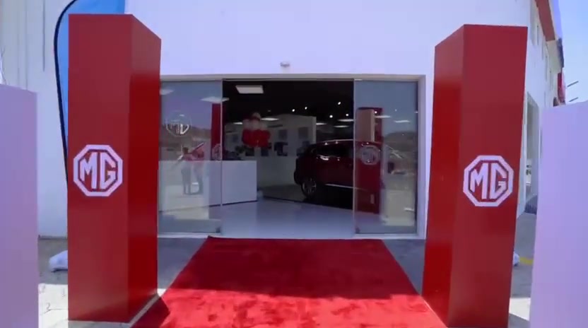Red MG-branded entrance pillars and carpet leading into the showroom