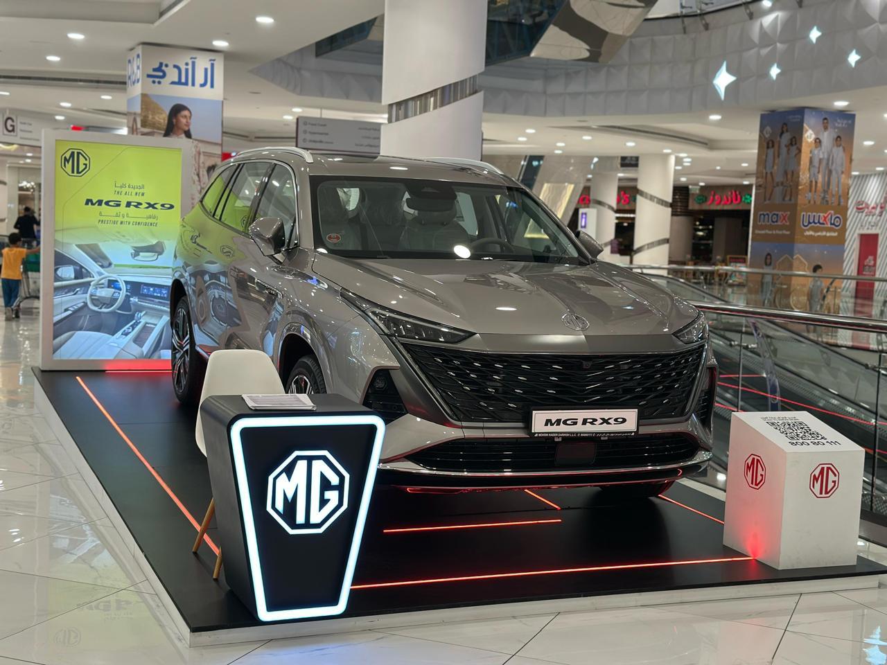 An MG vehicle on a branded platform in a shopping mall.