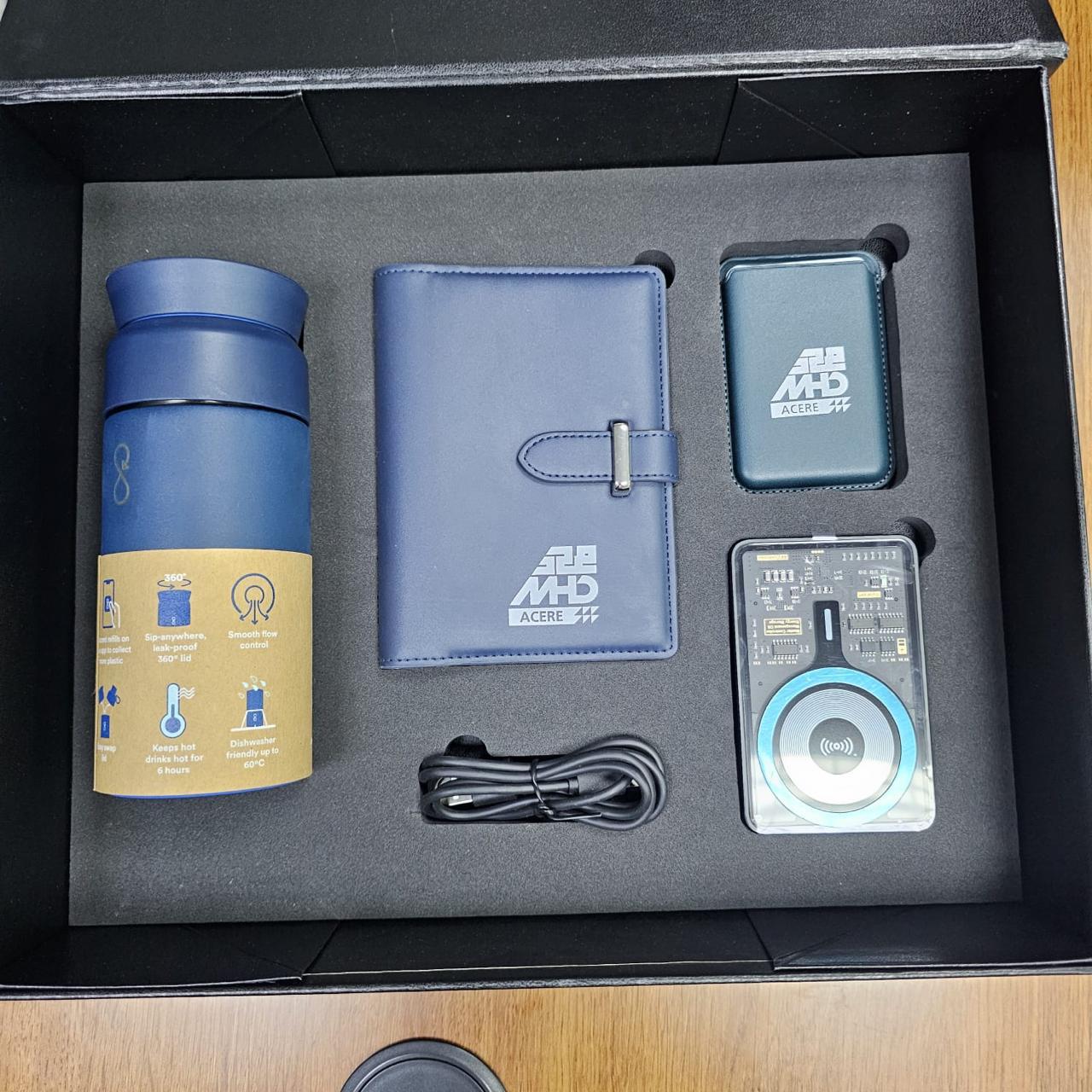 An MHD-branded gift box with a tumbler, organiser and electronic accessories.